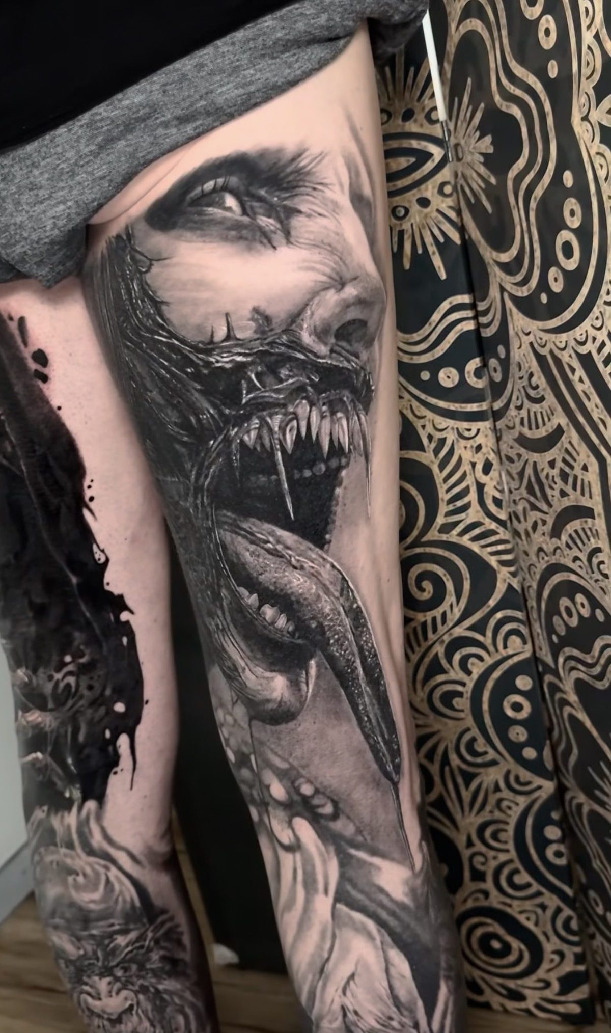 Horror creature with an open mouth, black and grey realism tattoo by Ruby Ink